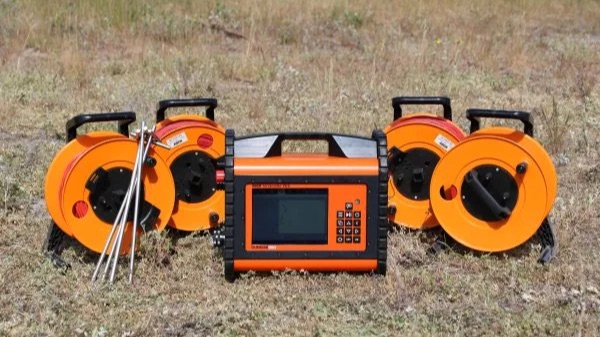 Resistivity instrument with four orange cable reels on grass