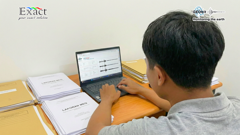 Operator sedang mengecek data secara remote dari meja kantor.