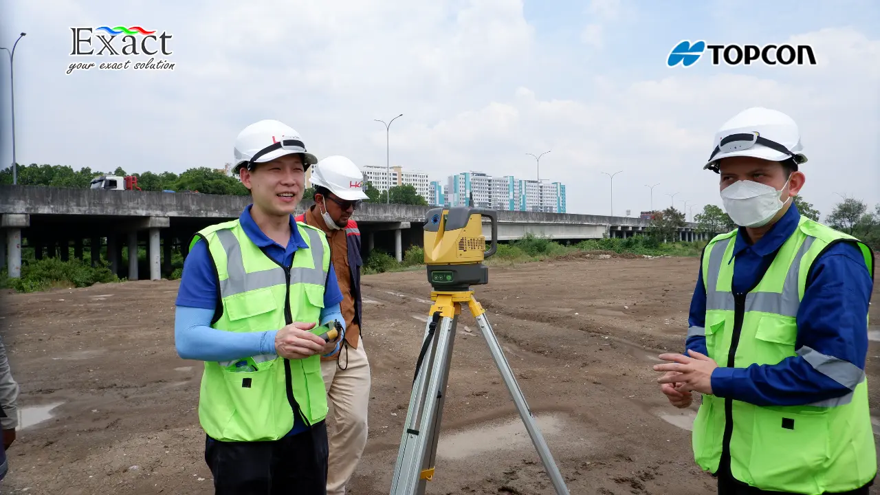 Operator sedang mengoperasikan alat Topcon ESN-100 dengan latar belakang struktur jembatan layang beton.